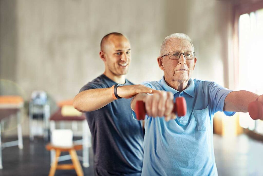 A person performing gentle leg exercises at home with supportive props and natural sunlight.